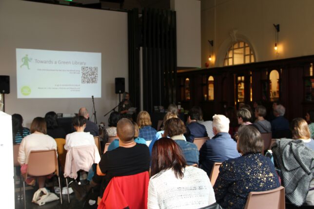 A photo of the attendees of the Towards a Green Library event, who are facing a powerpoint.