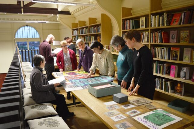 A group of people in the GWL mezzanine looking at archive material.