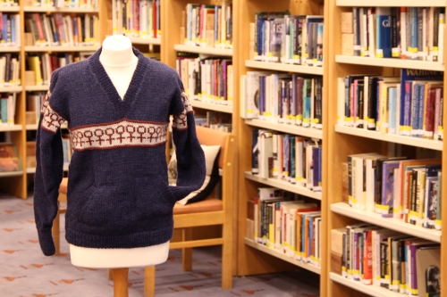 Blue v-neck jumper in between library shelves