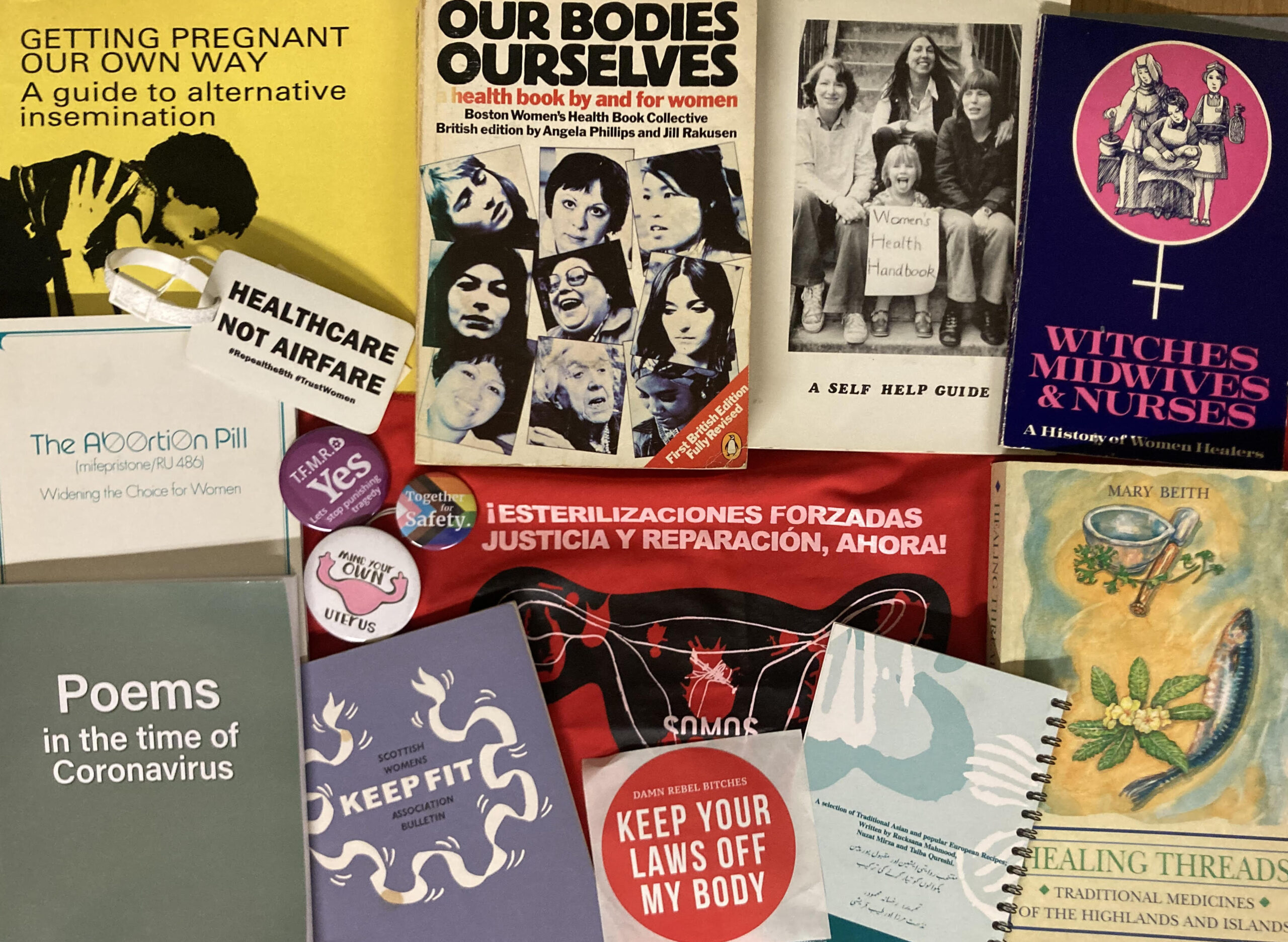 A photo of different materials from Glasgow Women's Library's collections on women's health and wellbeing, laid flat on a table.