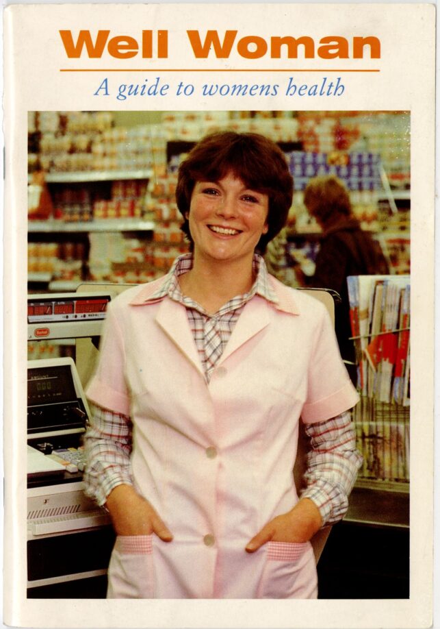 The front cover of the Well Woman booklet, with a full colour photo of a smiling woman next to a shop till, wearing a check shirt and a pink coverall.