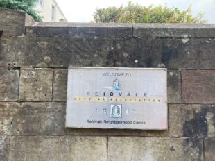 Signage for Reidvale Housing Association on a wall outside
