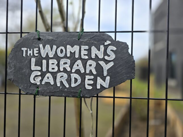 Photograph of a slate sign with text "the Women's Library Garden" painted on it.
