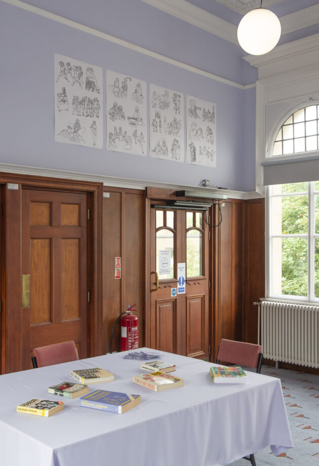 View of community room with illustration posters on lavender wall.