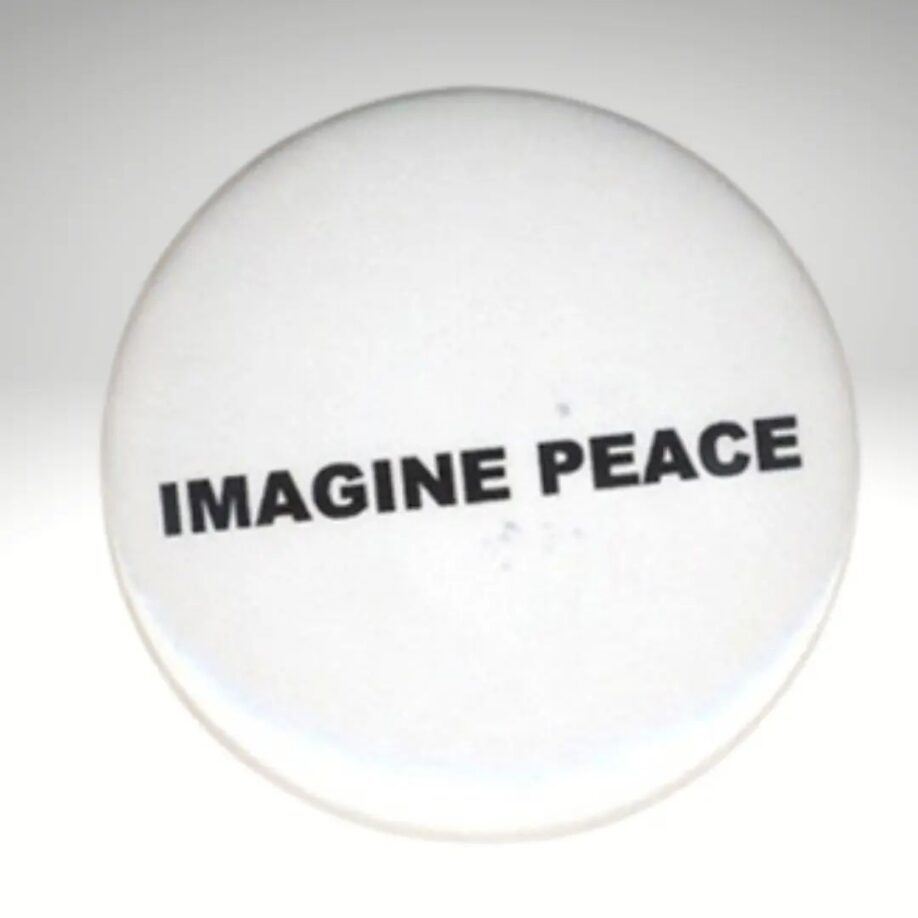 A white badge on a white background reads 'Imagine Peace' in black block capital letters