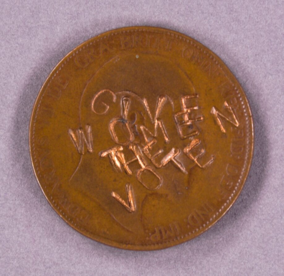 A penny with the head of King Edward VII stamped with the words 'Give Women The Vote' in capitals.