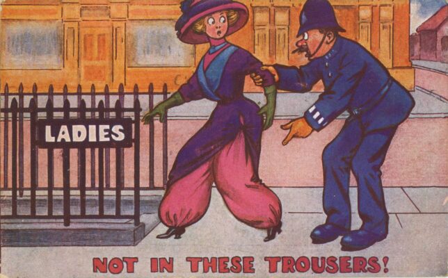Postcard depicting a uniformed policeman grabbing the arm of a woman in purple tunic and pink harem pants as she heads towards a ladies' public toilets; captioned 'NOT IN THESE TROUSERS!'. 