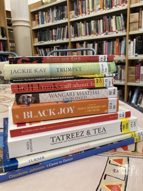 A pile of books written by Black writers and selected from the GWL collection, stacked on a table in the library.