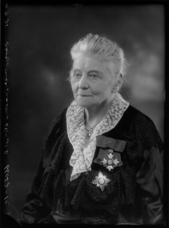 A black and white portrait photo of Dame Louisa Lumsden from 1925. She's an elderly ladÿ, dressed in black with a collar of white lace and two medals pinned to her chest.