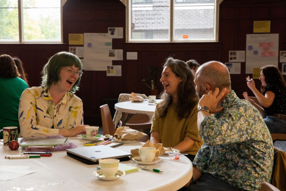 Event attendees laughing as they chat around a table in our main event space