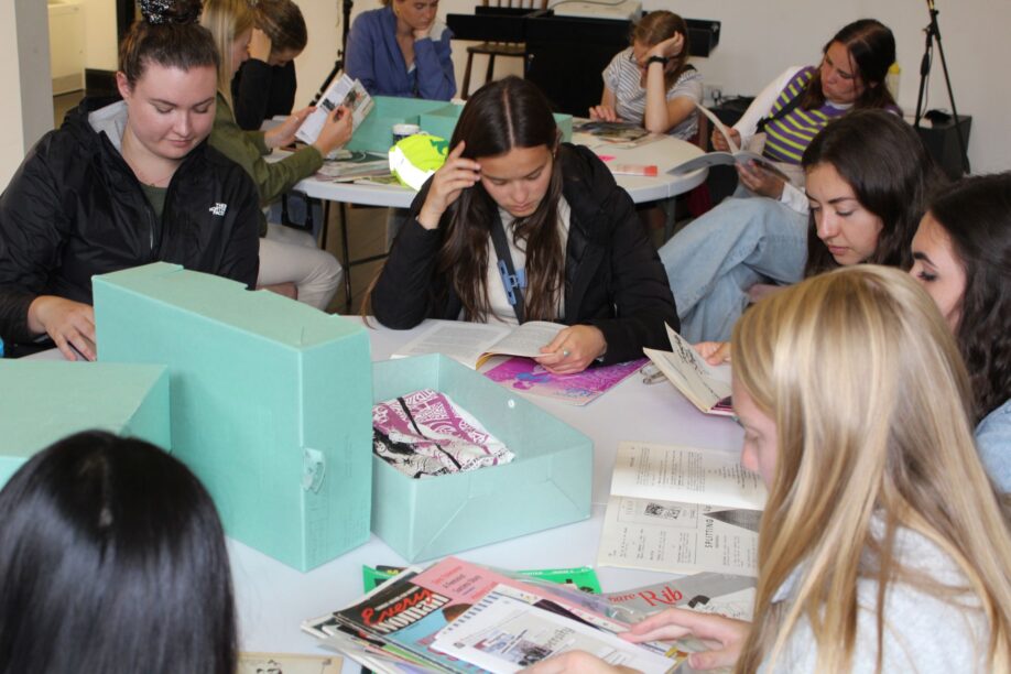 Students seated round tables engrossed in journals from our collection.