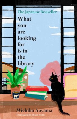 A black cat sits and looks out a house window with a pile of books next to him. Outside is a pink tree and blue sky