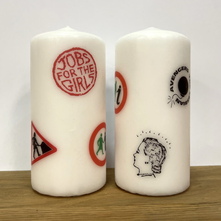 Two large candles with several logos from GWL's past