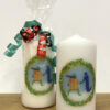 Two candles with a festive-themed version of the GWL logo - one is wrapped with cellophane and tied with ribbons.