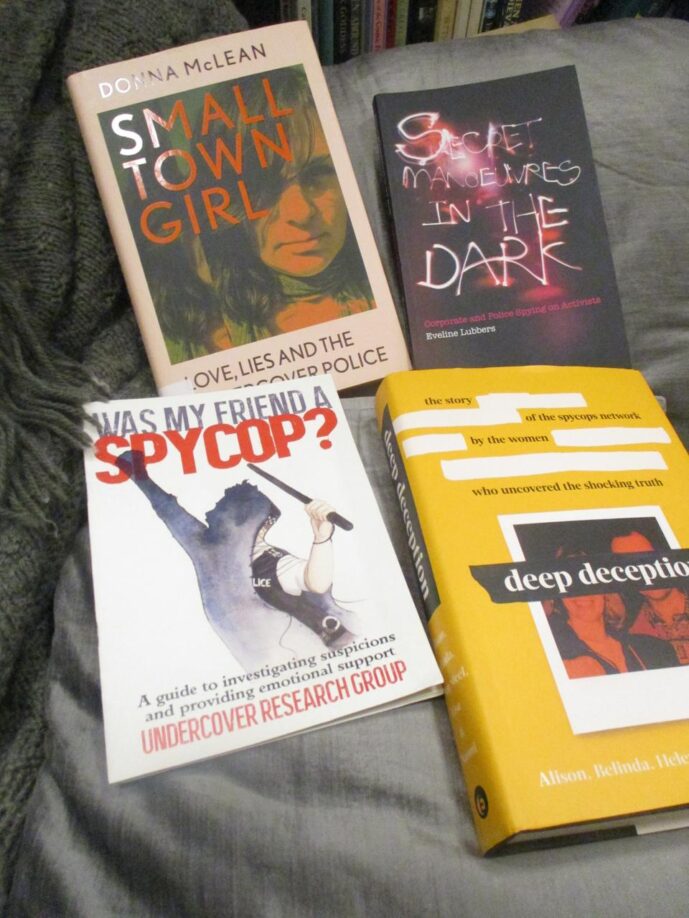 
A display of four books; ‘Small Town Girl’ by Donna McLean, ‘Secret Manoeuvres in the Dark’ by Eveline Lubbers and ‘Deep Deception’, collectively written by five of the women from the Police Spies Out of Lives group, and ‘Was My Friend a Spycop?’ by [an] Undercover Research Group. 
