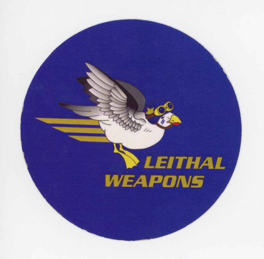 Round blue sticker with the words "Leithal Weapons" in yellow, block letters under an image of a flying bird