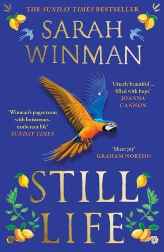 The book cover, Still Life by Sarah Winman. It is bright blude and has a parrot on the front.